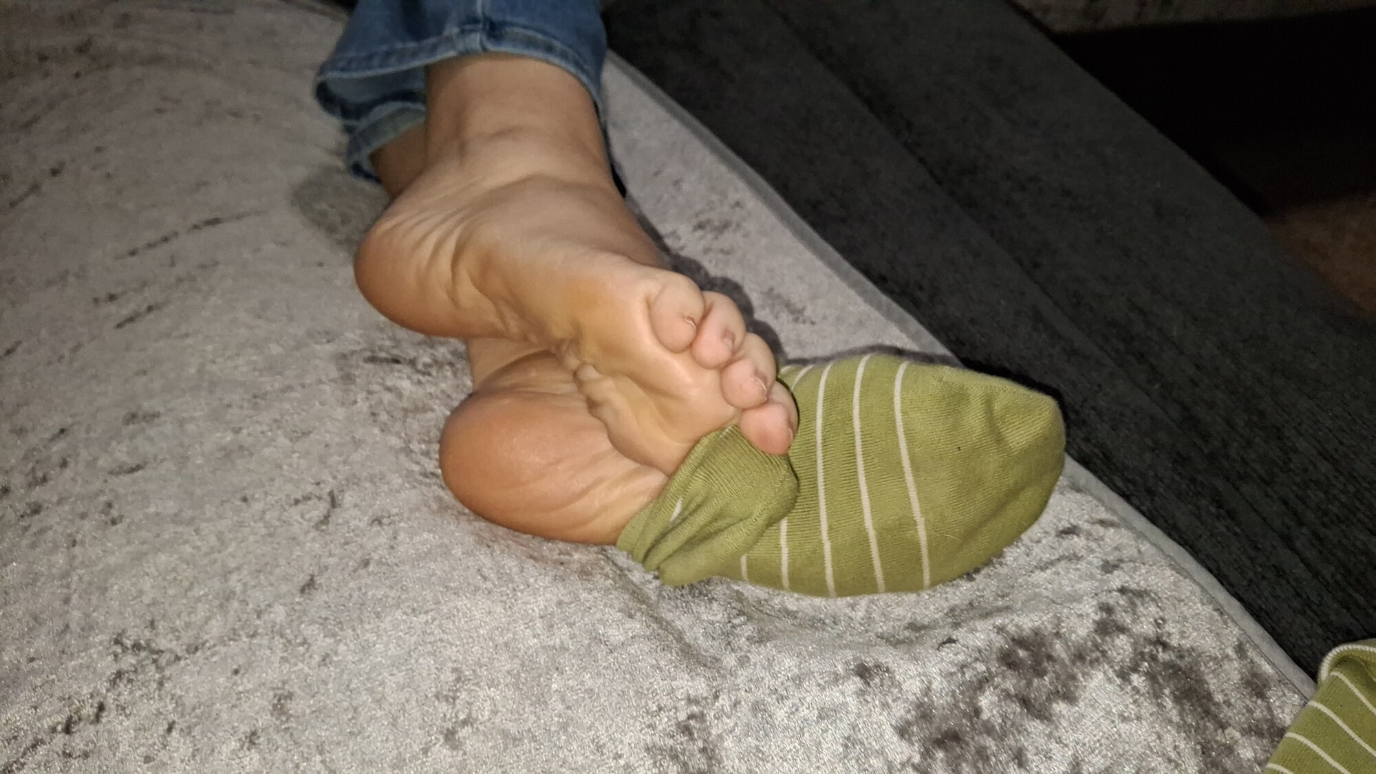 Çoraplarıyla oynuyor ve tekrar giyiyor