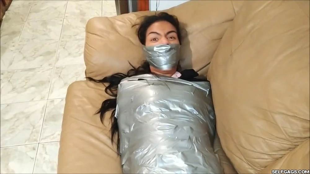 Kendini ağzı tıkanmış kız, sıkıca bantla sarılmış - selfgags