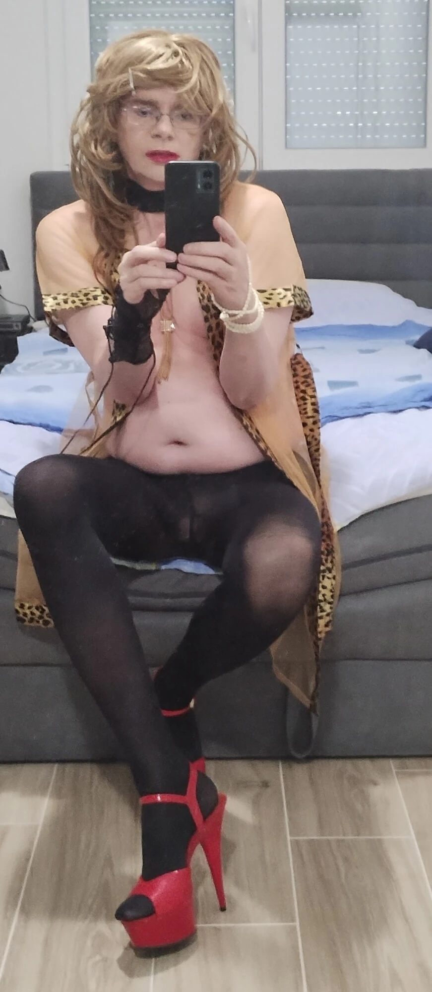 Travesti orta yaşlı seksi kadın yeni şık iç çamaşırıyla yarı çıplak oturuyor